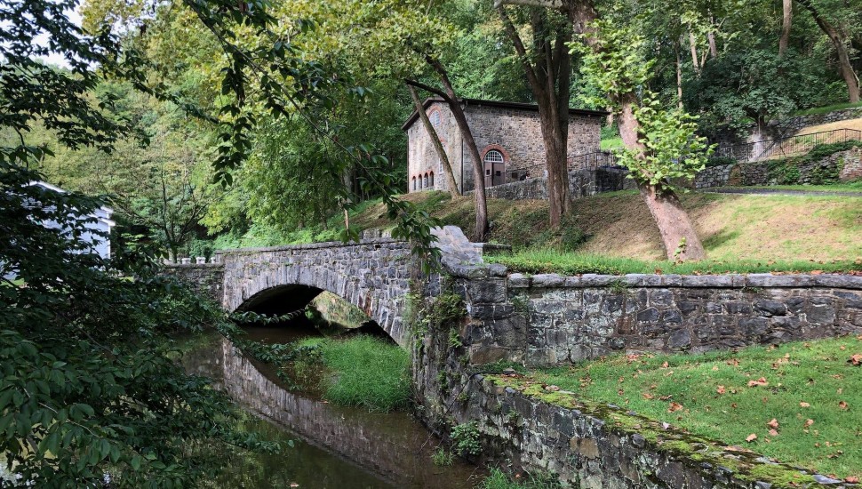 A country stone bridge over a creek on a beautiful summer day.