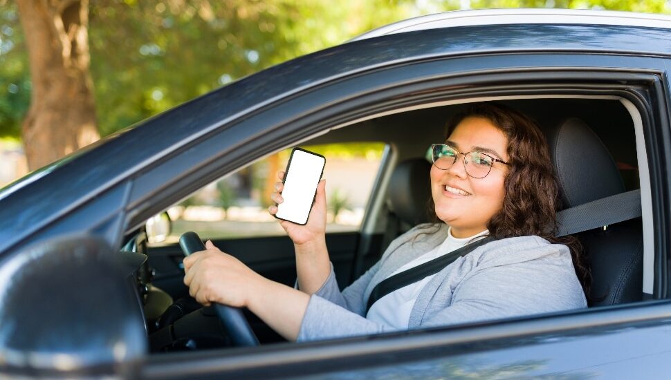 a Young woman food delivery driver holding up her cell phone