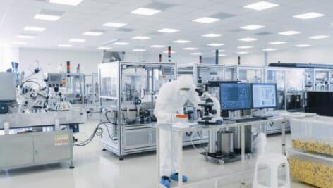 Sterile Pharmaceutical manufacturing laboratory where scientists in protective coverall's do research, quality control and work on the discovery of new medicine.