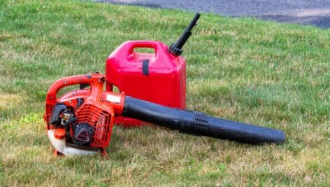 A gas-powered leaf blower with a gas can next to it.