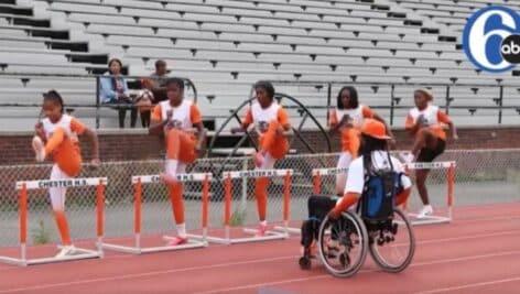 Coach Jamal Allen instructs his Chester student track athletes on the field.