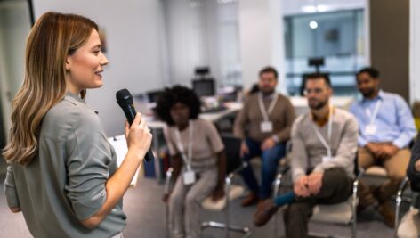 Young business woman gives a presentation to an audience.