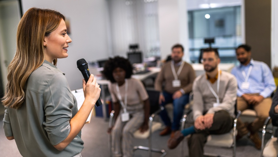 Young business woman gives a presentation to an audience.