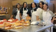 Employees at the Chester Kyj's Chester store gather around the decoration table for the strawberry shortcake.