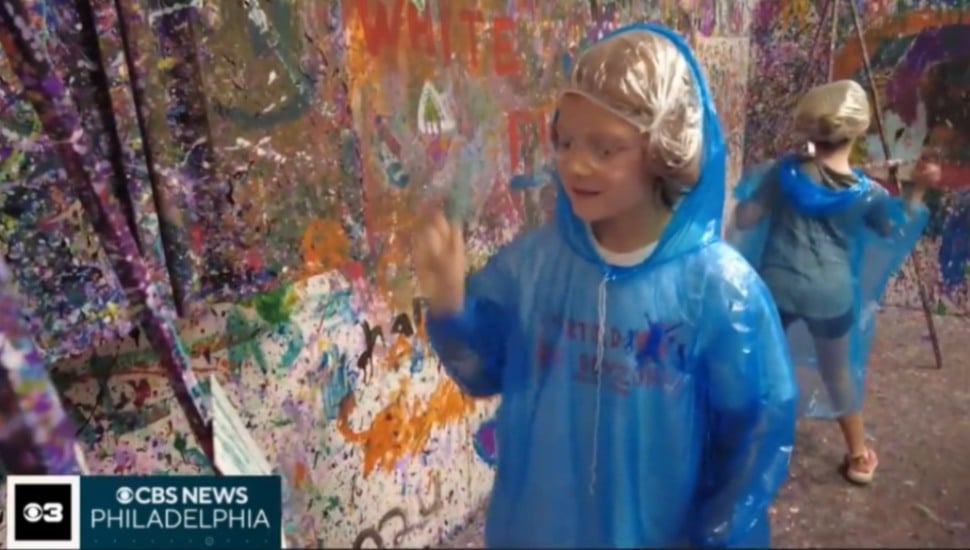 Two girls give splatter art a try at A Flick of the Wrist Splatter and Paint in Malvern.