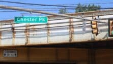 A Chester Pike road sign on a rusty-looking bridge.