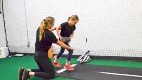 Julie Sebastian gives instructions to a young girl softball player.