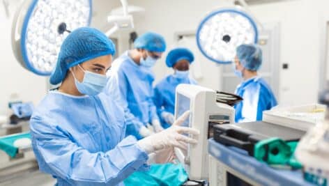 Anesthesiologist keeping track of vital functions of the body during cardiac surgery.