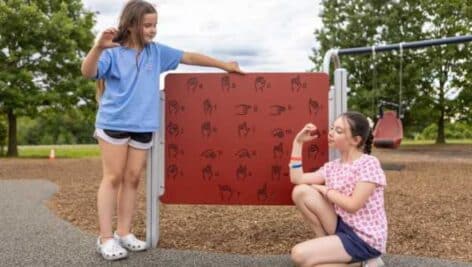 Two children try out a communication s board a the new Warminster Community Park playground in Bucks County.