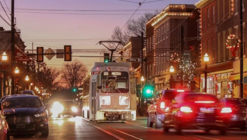 A trolley cruises down State Street amid traffic in Media Borough