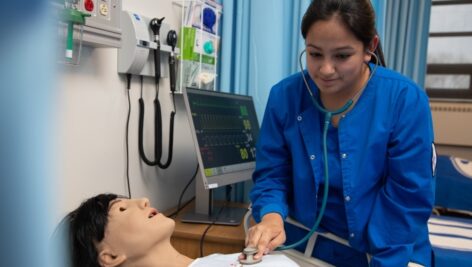 Undergraduate nursing student practicing skills on a dummy.