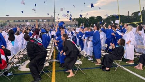 Springfield High School graduates toss their caps at a graduation ceremony.