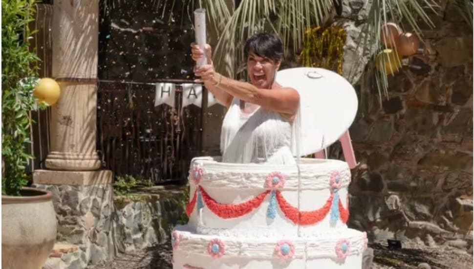 Susan Noles jumps out of a cake on an episode of The Golden Bachelor.