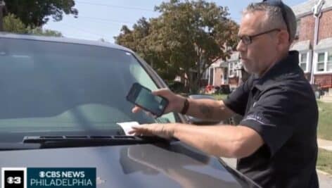 A parking enforcement officers puts a warning on a parked car in a Chester neighborhood.