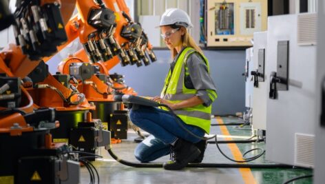 Female engineer checking and controlling parts of robotic machine. According to the October 2024 Manufacturing Business Outlook Survey, manufacturing activity in the Philadelphia region expanded overall.