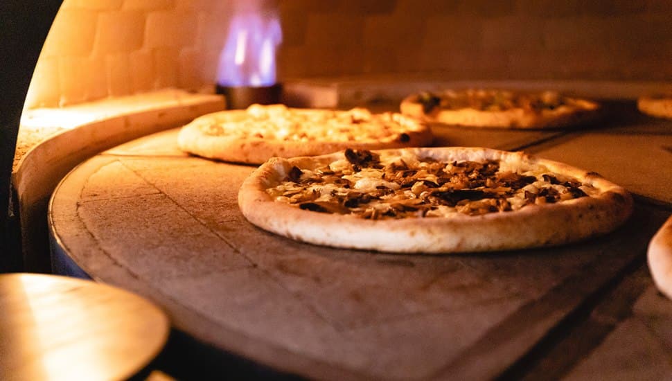 Pizzas baking in a pizza oven at LaScala's Fire in Newtown Square.