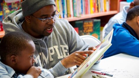 Man reading to a young boy at Treehouse Books.