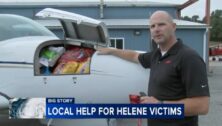 PIC Jonathan Martin, director of aviation for New Garden Flying Field shows where supplies are stored on aircraft providing relief to North Carolina victims.