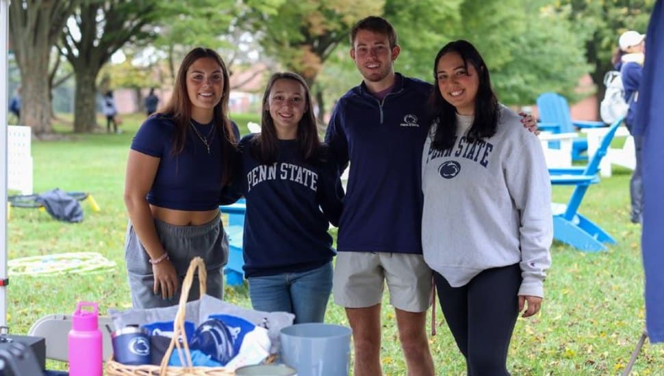 Four Penn State Brandywine students post for a photo at the Penn State Brandywine Homecoming and Family Day.