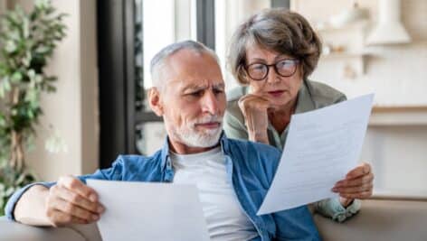 An older couple looking over some documents.