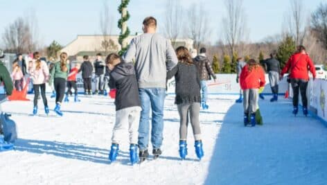 A crowd of skaters, including a dad and his two kids, at the Flight on Ice skating rink.