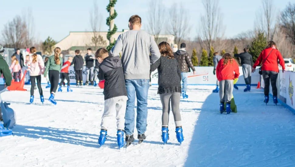 A crowd of skaters, including a dad and his two kids, at the Flight on Ice skating rink.