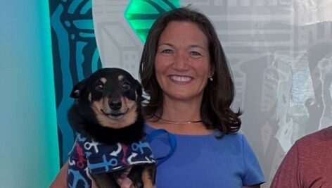 A woman holds her smiling dog.