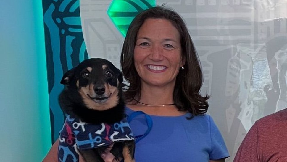 A woman holds her smiling dog.