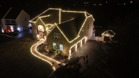 A home and walkway decorated with white holiday lights.