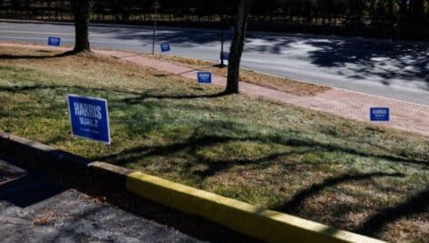 Some Harris/Walz political signs on a lawn.