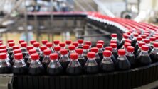 Bottles of soda on a conveyor belt.