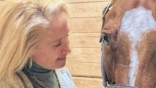 Deanna Manfredi gazes happily at her horse.