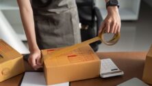 A worker seals a package for shipping.