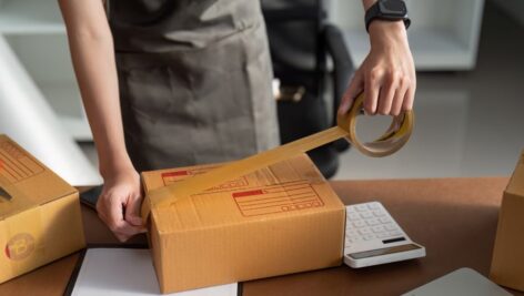 A worker seals a package for shipping.