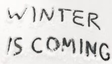 Windshield with "winter is coming" carved in the snow