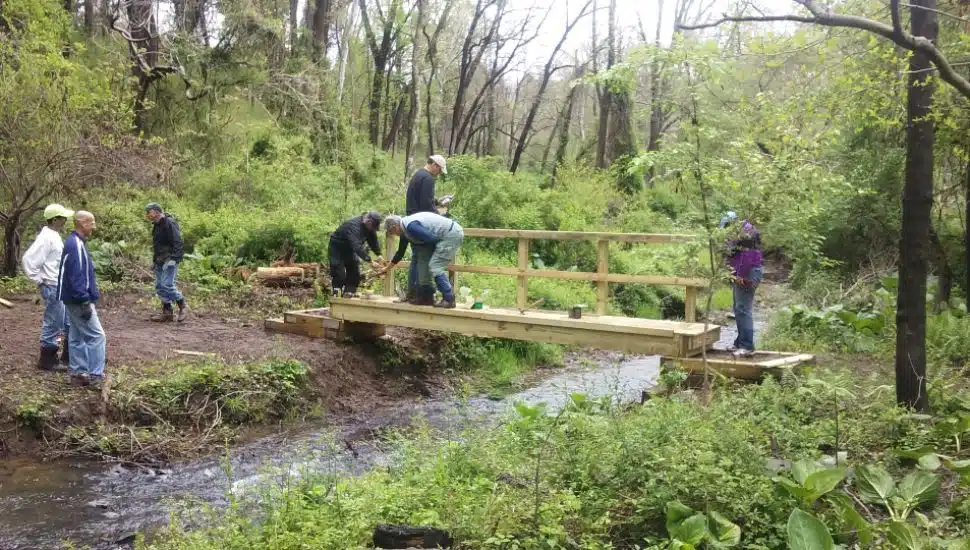 Volunteers from the Friends of Ridley Creek State Park work on a trail bridge at the park.