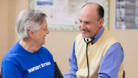 A doctor talks with a Dunwoody Village resident wearing a "Dunwoody Strong" shirt.