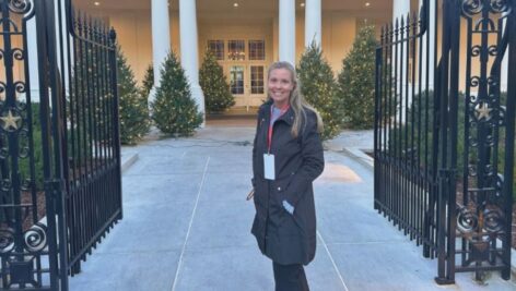 Nicole Radio of West Chester, a White House Christmas decoration volunteer, stands at the gates to the White House entrance.