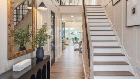 A hallway and foyer with stairs inside a new Toll Brothers home.