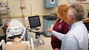 respiratory care teacher instructs student in simulation lab