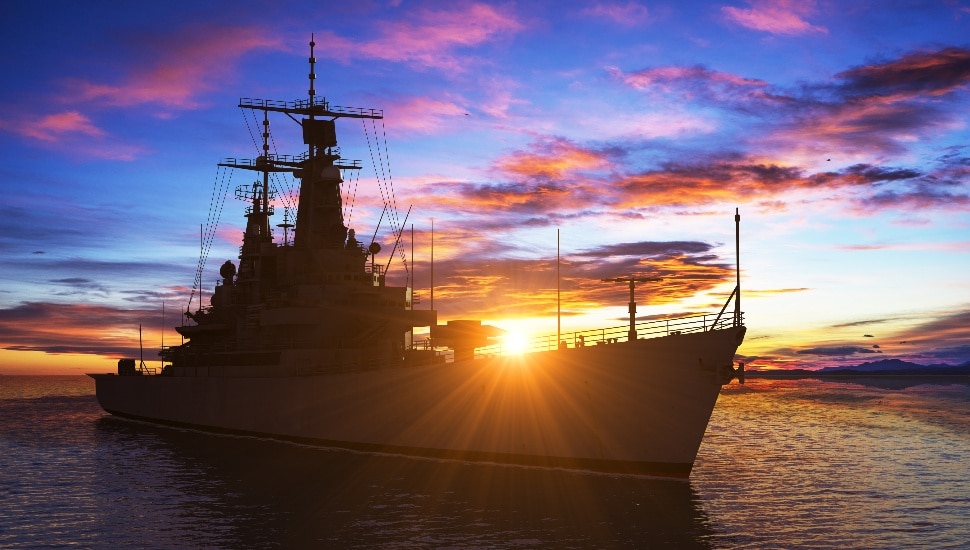 An American modern warship at sunset.