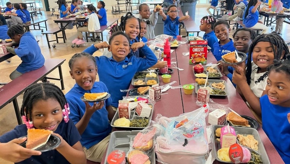 Students eat lunch in a school cafeteria.
