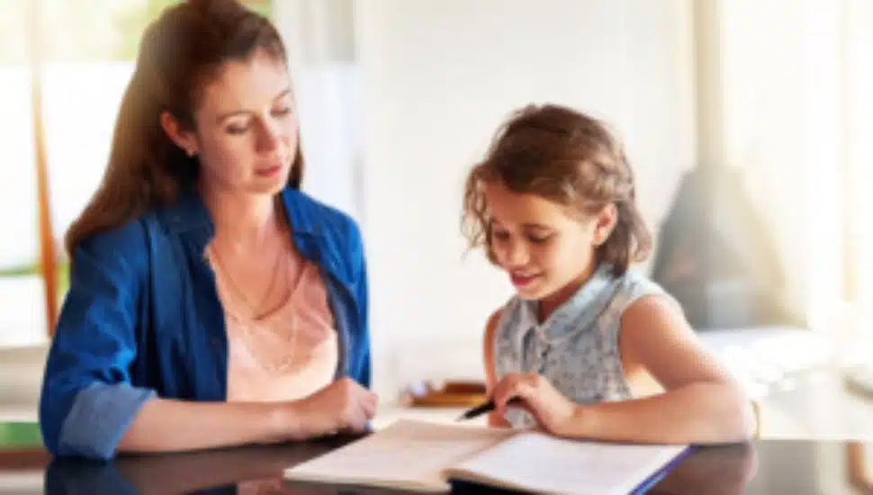 A mom helps her young daughter with her growth journal.