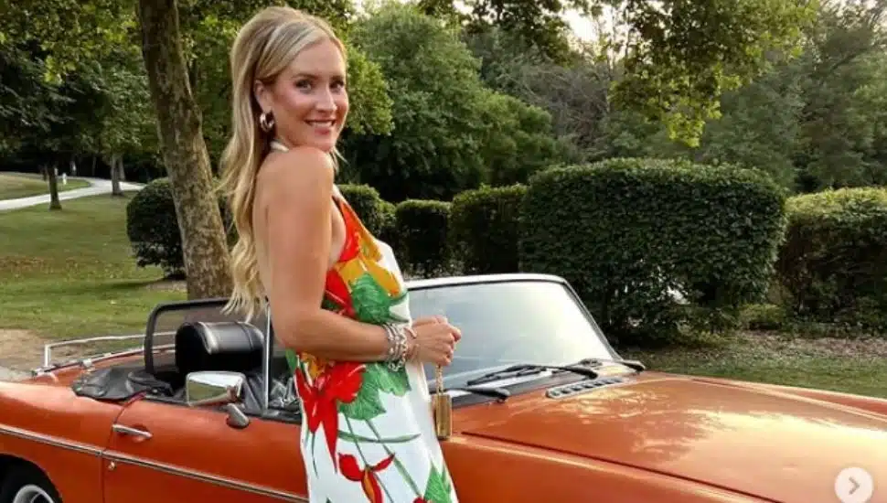 Hillary Berenato in a colorful dress next to a car.