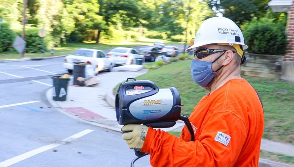 Utility worker uses technology to detect presence of natural gas.