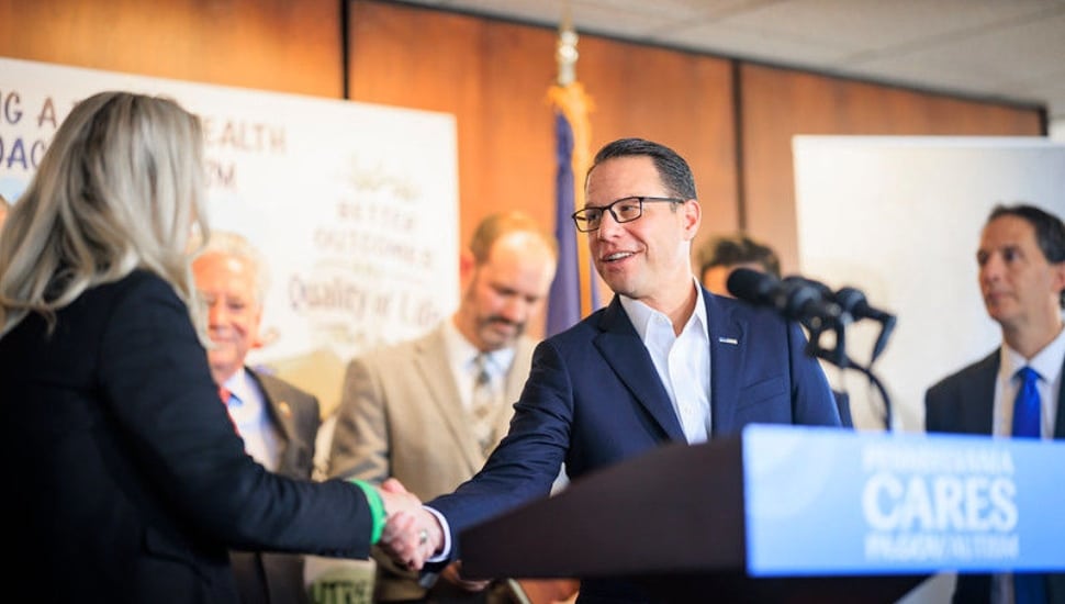 Pennsylvania Gov. Josh Shapiro shakes the hand of an unidentified woman.