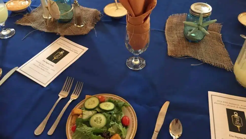 The meal is prepared and the table set at a catered event.