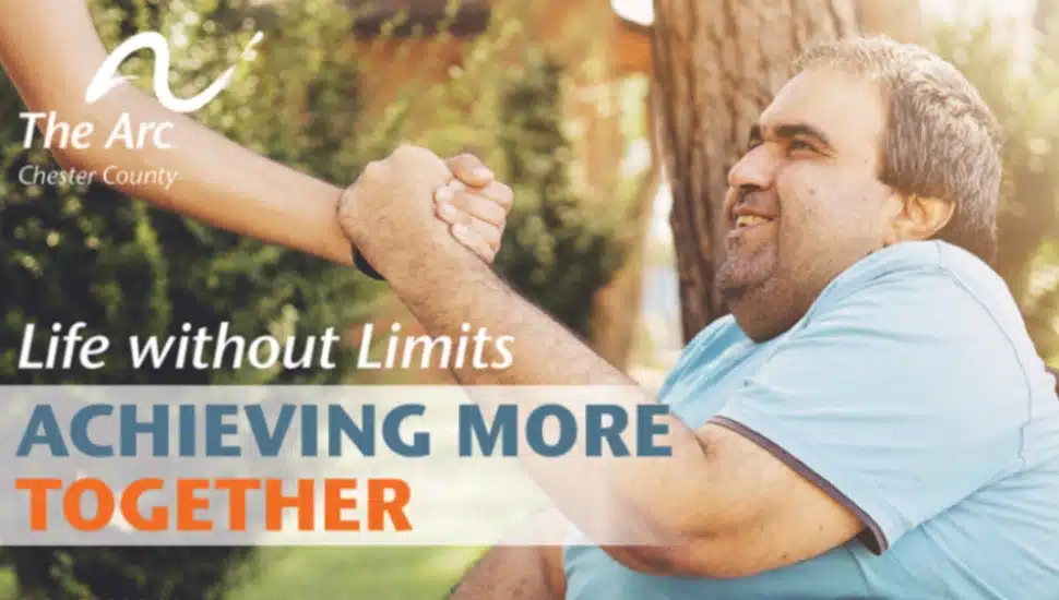A promotion from the Arc of Chester County showing a man in a wheelchair clasping hands with another person, in celebration of Developmental Disabilities Awareness Month.