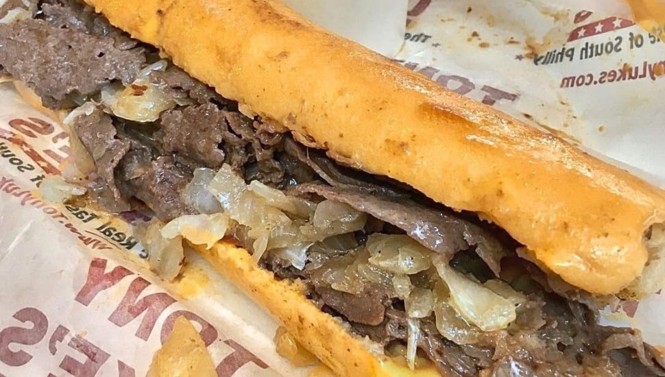 A cheesesteak resting on a counter.