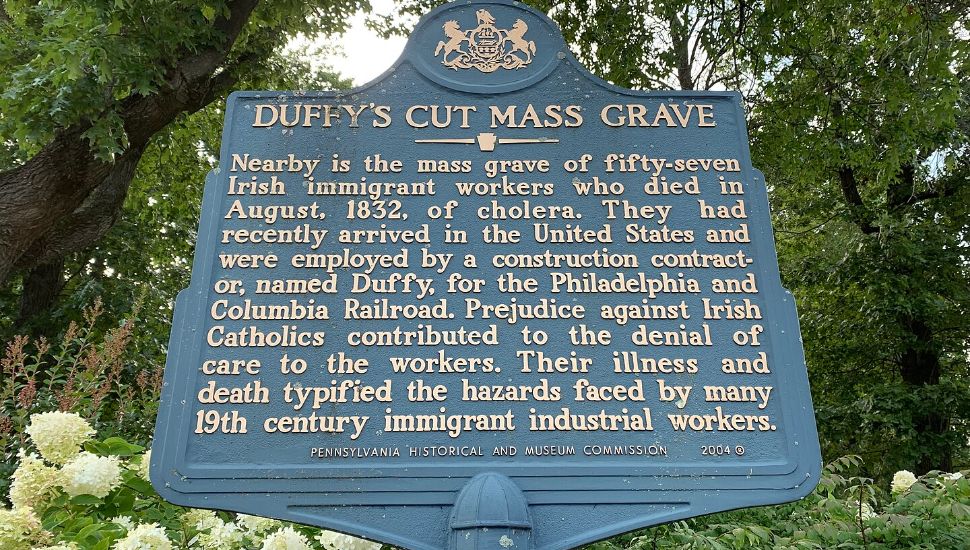 A historical marker with information about Duffys Cut Mass Grave.
